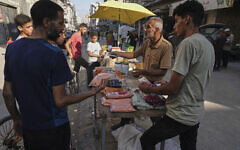 A Palestinian vendor displays goods for sale at a street market in Gaza City, July 23, 2025. (AP Photo/Jehad Alshrafi)