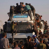 Palestinians ride on a truck loaded with food and humanitarian aid as it moves along the Morag corridor near Rafah, in the southern Gaza Strip, August 4, 2025. (AP/ Mariam Dagga)