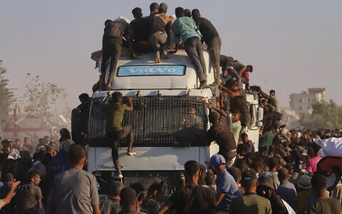 Palestinians ride on a truck loaded with food and humanitarian aid as it moves along the Morag corridor near Rafah, in the southern Gaza Strip, August 4, 2025. (AP/ Mariam Dagga)