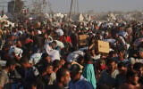 Palestinians carry packages of food taken from a humanitarian aid convoy that moved along the Morag corridor near Rafah, in the southern Gaza Strip, August 4, 2025. (AP Photo/Mariam Dagga)