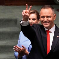 Poland's new President Karol Nawrocki, with his wife Marta Nawrocka, shows a V-sign during the inauguration ceremony in Warsaw, Poland, on Wednesday, August 6, 2025. (AP Photo/Czarek Sokolowski)