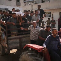Palestinians carry the body of a person who was killed while trying to reach aid trucks entering northern Gaza Strip through the Zikim crossing with Israel, at Shifa Hospital in Gaza City, August 6, 2025. (Jehad Alshrafi/AP)