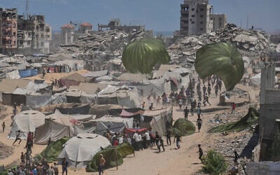Palestinians rush to collect humanitarian aid airdropped by parachutes into Gaza City, northern Gaza Strip, August 7, 2025. (AP Photo/Jehad Alshrafi)