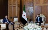 In this handout photo released by the Turkish Foreign Ministry press service, Turkish Foreign Minister Hakan Fidan, left, sits with Syria's interim President Ahmad Al-Sharaa, during their meeting in Damascus, Syria, on August 7, 2025. (Turkish Foreign Ministry via AP)