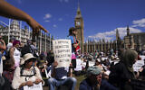 A demonstrator holds a placard during a protest in support of Palestine Action, in Parliament Square, in London, August 9, 2025. (AP Photo/Alberto Pezzali)