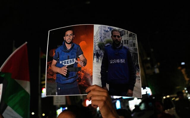 A woman carries a poster showing Palestinian journalists Anas al-Sharif, whom Israel says was a Hamas operative, left, and Mohamed Qreiqeh, whom Israel's military targeted and killed in an airstrike late Sunday in Gaza, during a protest in the West Bank city of Ramallah, August 11, 2025. (AP Photo/Nasser Nasser)