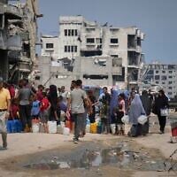Palestinians line up to collect water from a distribution point in Gaza City during a heatwave, August 12, 2025. (AP Photo/Jehad Alshrafi)