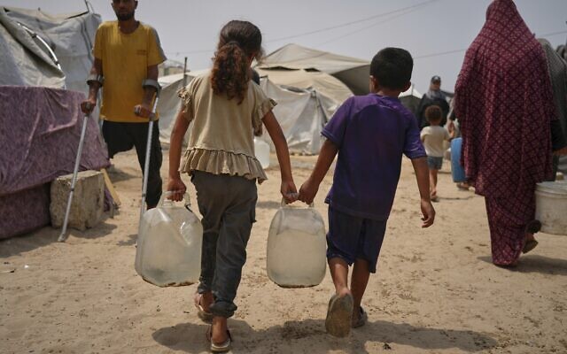 In the summer heat, Palestinian children carry jerrycans after collecting water from a distribution point in Gaza City, August 12, 2025. (AP Photo/Jehad Alshrafi) In the summer heat, Palestinian children carry jerrycans after collecting water from a distribution point in Gaza City, August 12, 2025. (AP Photo/Jehad Alshrafi)