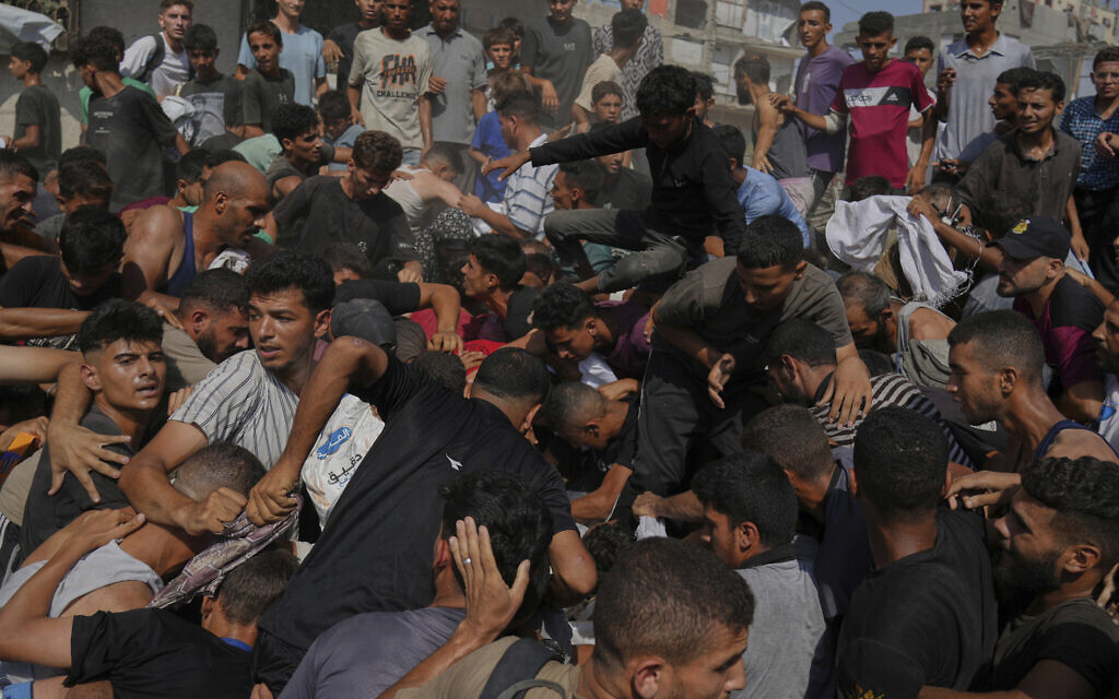 Palestinians struggle to collect humanitarian aid airdropped into Gaza City, in the northern Gaza Strip, August 14, 2025. (AP Photo/Jehad Alshrafi)