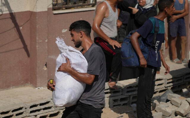 A Palestinian collects humanitarian aid after it was airdropped into Gaza City, northern Gaza Strip, August 14, 2025. (AP Photo/Jehad Alshrafi)