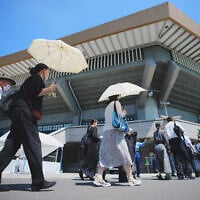 Guests on their way to attending a memorial service marking the 80th anniversary of Japan's World War II defeat, at the Nippon Budokan Hall Friday, August 15, 2025, in Tokyo. (AP/Eugene Hoshiko)