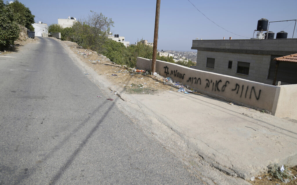 Hebrew graffiti reads "death for the enemy, freedom for the homeland," is seen following a rampage by Israeli settlers overnight in the West Bank town of Atara, north of Ramallah Friday, August 15, 2025. (AP Photo/Nasser Nasser)