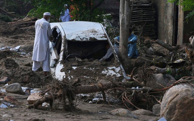Local residents look at a car trapped in the mud after flash flooding on the outskirts of Pir Baba, Buner district, in Pakistan's northwest, August 16, 2025. (AP/Muhammad Sajjad) Local residents look at a car trapped in the mud after flash flooding on the outskirts of Pir Baba, Buner district, in Pakistan's northwest, August 16, 2025. (AP/Muhammad Sajjad)