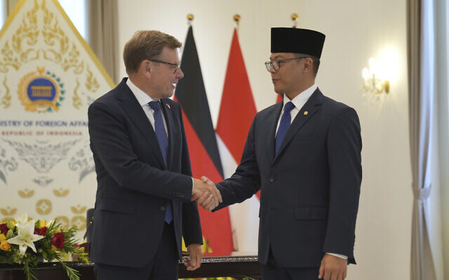 German Foreign Minister Johann Wadephul, left, is greeted by his Indonesian counterpart Sugiono during their meeting in Jakarta, Indonesia, Wednesday, Aug. 20, 2025. (AP Photo/Dita Alangkara)