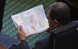 Texas state Sen. Pete Flores looks over a redrawn US congressional map during debate over a bill in the Senate Chamber at the Texas Capitol in Austin, Texas, Aug. 22, 2025. (AP Photo/Eric Gay)