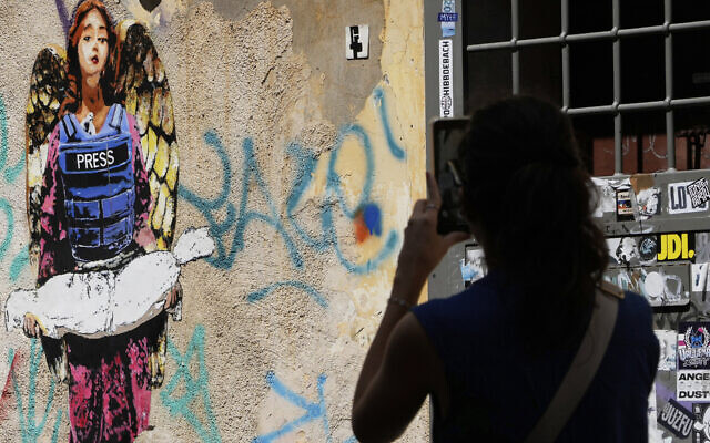 A woman takes a picture of the image "The Angel," painted earlier this year by street artist Harry Greb, dedicated to journalists killed in Gaza, showing an angel wearing a bulletproof vest with the word "Press" written on it and holding the body of a child, in Rome, Monday, Aug. 25, 2025. (AP/Gregorio Borgia) A woman takes a picture of the image "The Angel," painted earlier this year by street artist Harry Greb, dedicated to journalists killed in Gaza, showing an angel wearing a bulletproof vest with the word "Press" written on it and holding the body of a child, in Rome, Monday, Aug. 25, 2025. (AP/Gregorio Borgia)