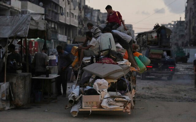 Displaced Palestinians fleeing Jabalia move with their belongings on a street in Gaza City, Aug. 26, 2025. (AP/Jehad Alshrafi)