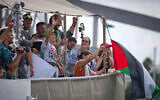 Swedish climate activist Greta Thunberg, center left, waves from a boat taking part in a civilian flotilla bound for Gaza, aiming to break the Israeli blockade on the Strip, in Barcelona, Spain, August 31, 2025. (AP Photo/Emilio Morenatti)