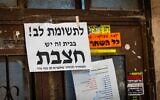A notice warning of measles is seen on a door in the ultra-Orthodox neighborhood of Mea Shearim in Jerusalem, July 31, 2025. (Chaim Goldberg/Flash90)