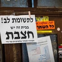 A notice warning of measles is seen on a door in the ultra-Orthodox neighborhood of Mea Shearim in Jerusalem, July 31, 2025 (Chaim Goldberg/Flash90)