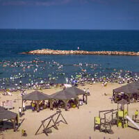 As an extreme heatwave takes hold, hundreds of ultra-Orthodox men and children enjoy the sea at Tel Aviv's religious beach, August 8, 2025. (Flash90)