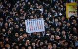 Ultra-Orthodox Jewish men block a road during a protest against the jailing of yeshiva students who failed to comply with an army recruitment order in Jerusalem on August 7, 2025. (Yonatan Sindel/Flash90)