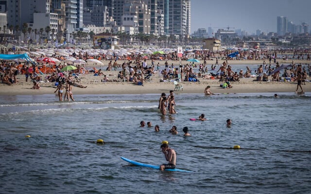 People enjoy at the beach in Tel Aviv, August 9, 2025. (Avshalom Sassoni/Flash90)