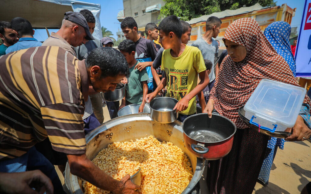Palestinians receive meals from volunteers in Gaza City, on August 10, 2025. (Ali Hassan/Flash90) Palestinians receive meals from volunteers in Gaza City, on August 10, 2025. (Ali Hassan/Flash90)