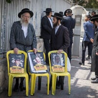 Ultra-Orthodox Jews protest outside army recruitment offices in Jerusalem on August 13, 2025. The pictures in the posters, mimicking those of Hamas-held hostages, are of arrested draft-dodgers with text urging their release. (Chaim Goldberg/ Flash90)