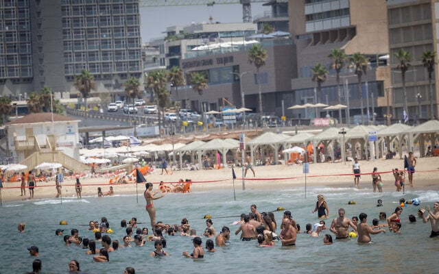 Israelis on the beach in Tel Aviv, amid record-breaking heat, August 13, 2025. (Miriam Alster/ Flash90)