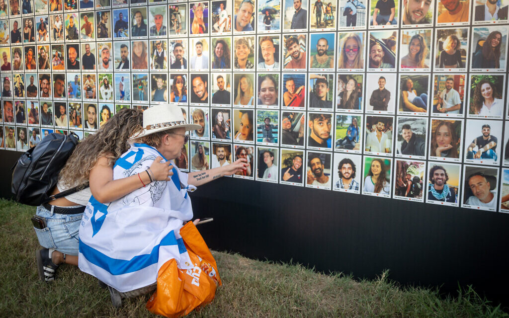 People look at photos of the victims of the October 7, 2023 Hamas attack on the Nova music festival, during the second annual Nova Healing Concert in Tel Aviv's Yarkon Park, August 14, 2025. (Chaim Goldberg/Flash90)