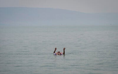 An Israeli floats in the Sea of Galilee amid a heatwave on August 14, 2025. (Michael Giladi/Flash90)
