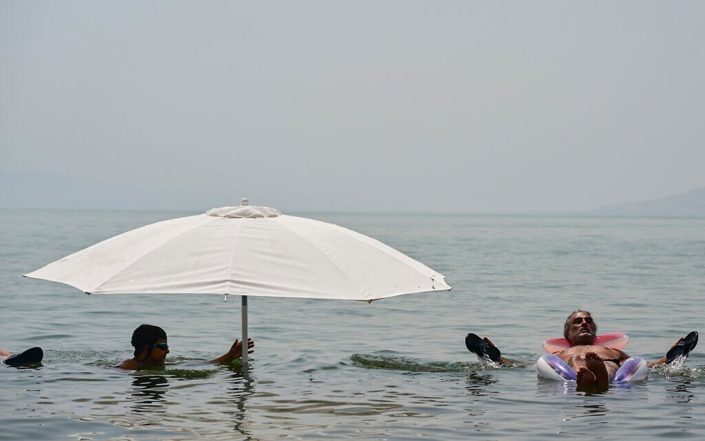 Israelis swim in the Sea of Galilee amid a heatwave, August 14, 2025. (Michael Giladi/Flash90)