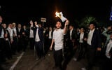 Ultra-Orthodox demonstrators burn enlistment orders at a demonstration outside the Beit Lid military prison, August 14, 2025. (Tal Gal/Flash90)