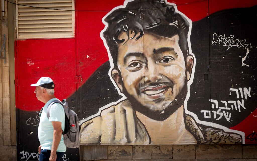 People walk next to a mural of slain Israeli-American hostage Hersh Goldberg Polin in central Jerusalem, August 18, 2025. (Chaim Goldberg/Flash90)