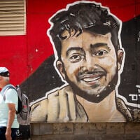 People walk next to a mural of slain Israeli-American hostage Hersh Goldberg Polin in central Jerusalem, August 18, 2025. (Chaim Goldberg/Flash90)