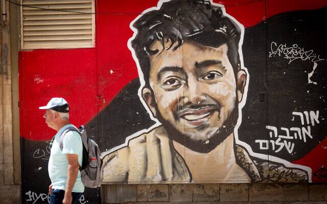 People walk next to a mural of slain Israeli-American hostage Hersh Goldberg Polin in central Jerusalem, August 18, 2025. (Chaim Goldberg/Flash90)
