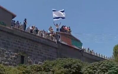 A man waves an Israeli flag during a demonstration by Druze in the southern Syrian city of Sweida calling for self-determination, August 16, 2025. (X screenshot) A man waves an Israeli flag during a demonstration by Druze in the southern Syrian city of Sweida calling for self-determination, August 16, 2025. (X screenshot)