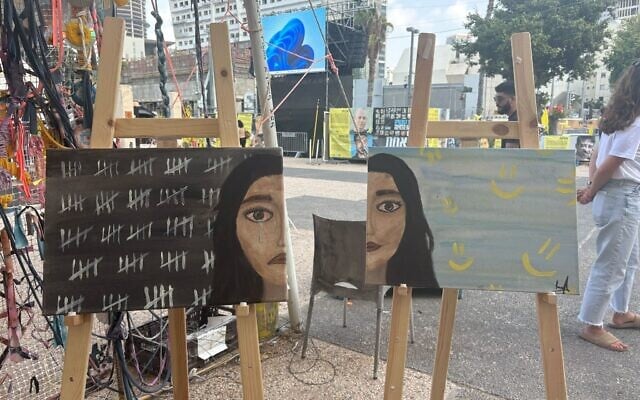 Two halves of a self-portrait by released hostage Liri Albag, displayed at Hostages Square in Tel Aviv on August 26, 2025. (Ariela Karmel/Times of Israel)
