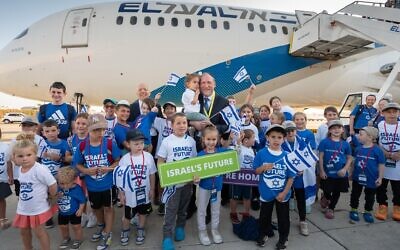 Rabbi Yehoshua Fass (center), co-founder and executive director of Nefesh B’Nefesh, and Tony Gelbart (rear left), co-founder and chairman of Nefesh B’Nefesh, together with the children arriving on the Charter flight (Shahar Azran)