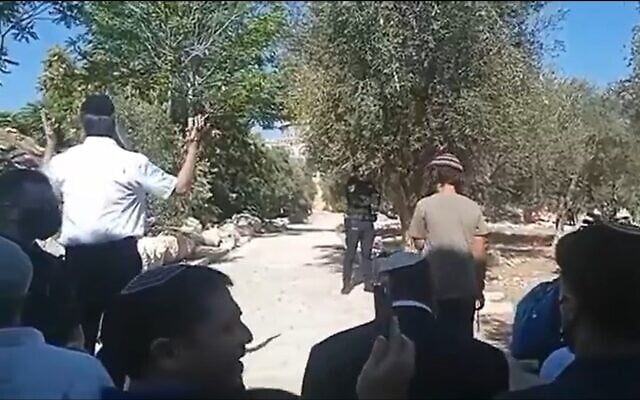 National Security Minister Itamar Ben Gvir, wearing a white kippa, takes part in a Jewish prayer service on the flashpoint Temple Mount in Jerusalem's Old City, August 3, 2025. (X video screenshot:  used in accordance with Clause 27a of the Copyright Law)