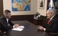 Prime Minister Benjamin Netanyahu looks at an amulet showing "a map of the Promised Land," given to him by his interviewer, August 12, 2025. (Screenshot i24 news) 