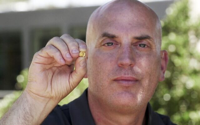 Archaeologist Yiftah Shalev of the Israel Antiquities Authority holding a recently unearthed Ptolemaic coin in Jerusalem's City of David on August 20, 2025. (Emil Aladjem/Israel Antiquities Authority)