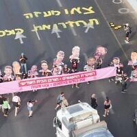 Protesters demanding a deal to free hostages in Gaza block Tel Aviv's Ayalon Highway and hold a banner reading, "Abandoning the hostages = the destruction of the Third Temple. Bring them home. Get out of Gaza," on August 3, 2025. (Aviv Atlas/Pro-Democracy Protest Movement)