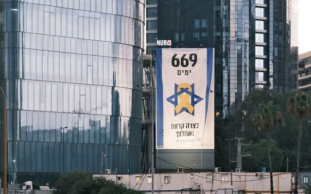 A banner over the Ayalon highway in Tel Aviv by former members of the IDF's search and rescue Unit 669 calls for the release of the hostages, and bears the unit’s Psalms motto: “In your distress you called and I delivered you," August 5, 2025. (Adar Eyal/Pro-Democracy Protest Movement)