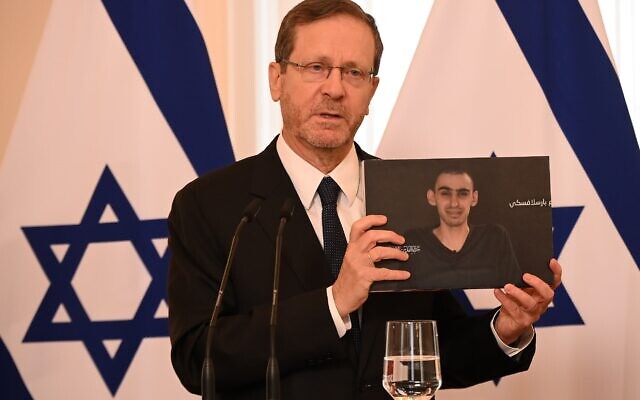 President Isaac Herzog holds up a photo of hostage Rom Braslavski during a joint press conference with Latvia's President Edgars Rinkevics (not pictured), in Riga, Latvia, on August 5, 2025. (Haim Tzach/GPO)