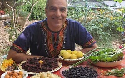 Dressed for the part: Wearing an African shirt, Ambassador Gideon Behar enjoys homegrown produce in his garden. (Courtesy)