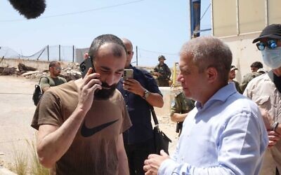 Israeli civilian Salah Abu Hussein (left) meets with Israel's coordinator for hostages and missing persons, Gal Hirsch, after being returned from Lebanon, on August 21, 2025. (Michael Dimenshtein/GPO)