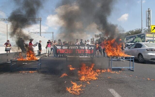 Teenage protesters demanding a hostage-ceasefire deal set fire to desks while blocking Tel Aviv's Ayalon Highway on August 31, 2025. (Noam Halaby-Senerman/Israeli Pro-Democracy Protest Movement)