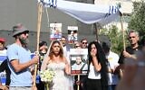 Ilana Gritzewsky (center), John Polin (left), and Einav Zangauker (right) stage a mock wedding between Gritzewsky and her boyfriend Matan Zangauker who is still being held captive in Gaza, on August 17, 2025, in Hostages Square in Tel Aviv (Paulina Patimer / Hostages and Missing Families Forum)